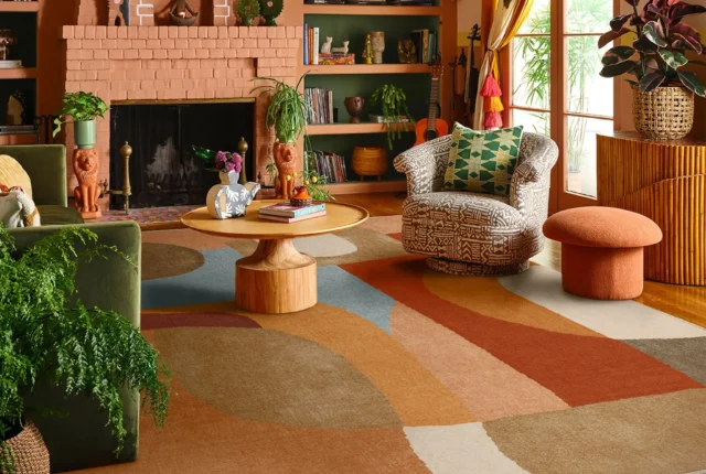 Un salon lumineux avec un grand canapé crème, un tapis en jute, quelques paniers en osier, et des plantes bien réparties : une Sansevière à côté du canapé, un Pothos suspendu dans un coin, et un Palmier bambou en fond, baignant dans une lumière douce et naturelle.