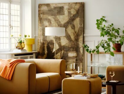 Un salon lumineux, mêlant un fauteuil en velours moutarde, un buffet scandinave vintage, une lampe champignon, et quelques plantes vertes.