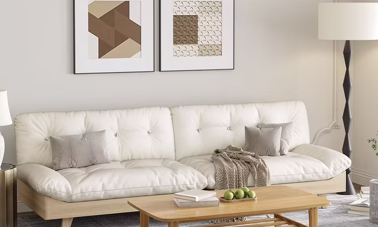 Un salon baigné de lumière naturelle, canapé en lin beige avec coussins doux, plaid en laine, table basse ronde en bois clair, lampe sur pied minimaliste, tapis structuré, et une plante haute dans un pot blanc mat.