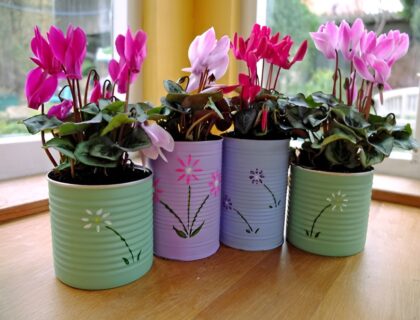 cache-pots faits maison : un bocal en verre habillé de ficelle, une boîte de conserve peinte couleur terracotta, un pot en tissu style denim
