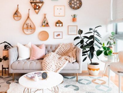 ambiance bohème chic, avec un mur blanc habillé d’un grand macramé, quelques cadres asymétriques et une étagère flottante avec une plante tombante