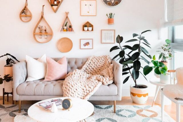 ambiance bohème chic, avec un mur blanc habillé d’un grand macramé, quelques cadres asymétriques et une étagère flottante avec une plante tombante