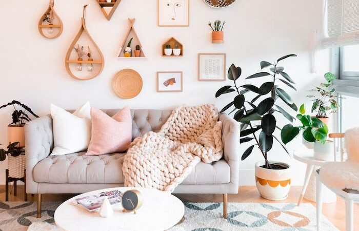 ambiance bohème chic, avec un mur blanc habillé d’un grand macramé, quelques cadres asymétriques et une étagère flottante avec une plante tombante