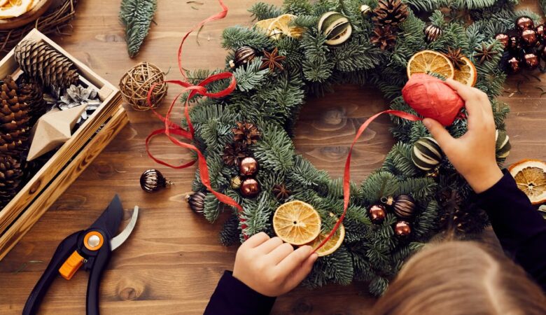 Une photo chaleureuse d’une couronne fait maison, des photophores scintillants et quelques décorations DIY éparpillées